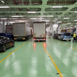 Załadunek pierwszych zestawów TIR i aut osobowych na pokładach samochodowych.